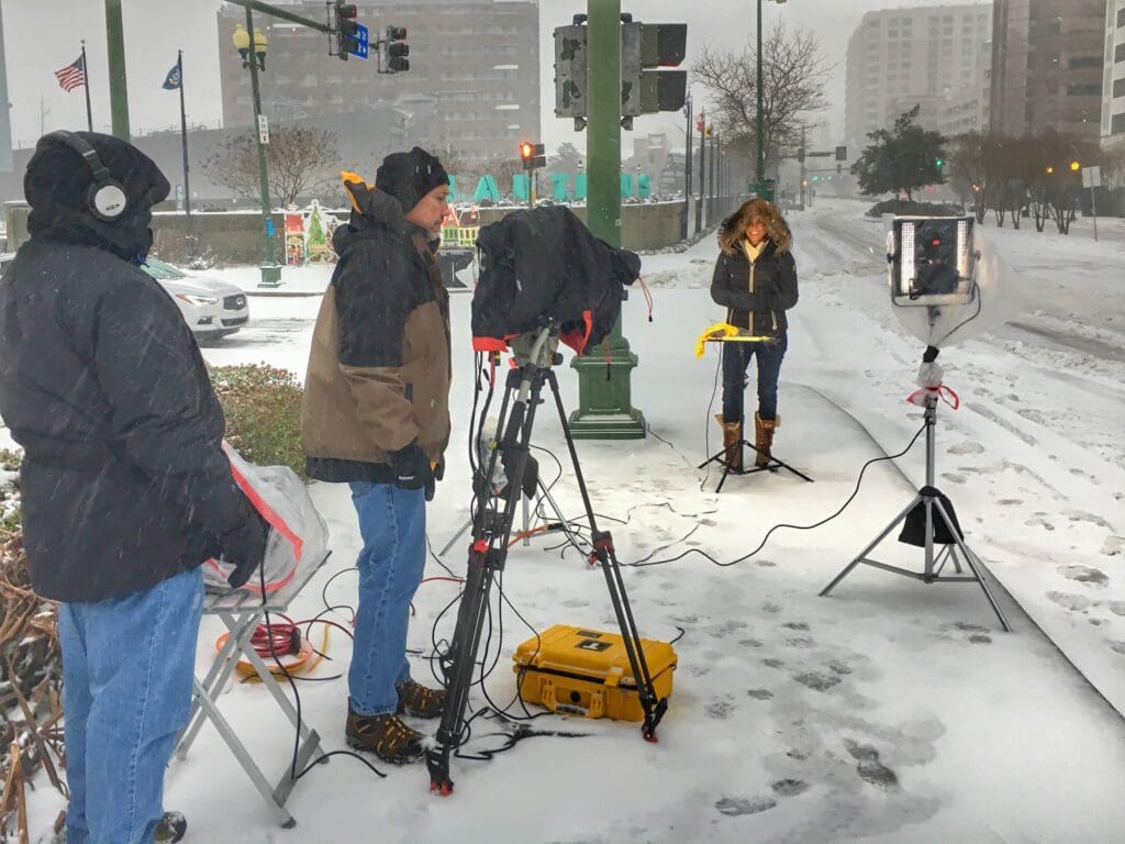 A group of people standing around in the snow.