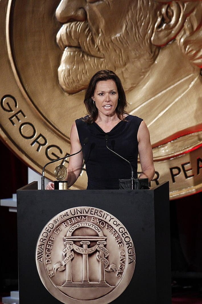 A woman standing at the top of a podium.